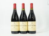 trois bouteilles de vin rouge posées l'une à côté de l'autre sur une surface blanche
