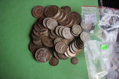 a bag of coins sitting on a table next to a pile of coins