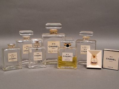 cinq flacons de parfum posés à côté d'une boîte d'allumettes