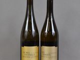 deux bouteilles de vin posées sur une table l'une à côté de l'autre