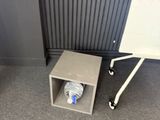 a bottle of water sitting on the floor next to a whiteboard