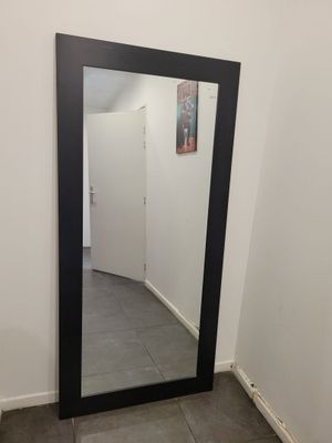 un grand miroir dans le coin d'une pièce