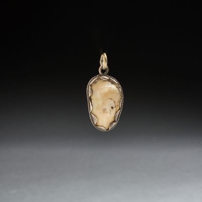 un pendentif en or et en argent représentant le visage d'une femme
