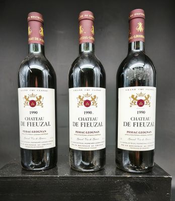 trois bouteilles de vin rouge sont posées sur un support en bois