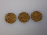 three gold coins, one of which is a sovereign and one of which is a sovereign