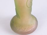 a glass vase with a green and pink design on it