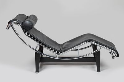 une chaise longue en cuir noir avec une structure en acier chromé