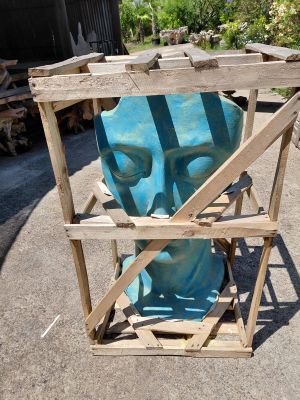 a blue sculpture of a man in a cage