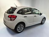 the rear of a white car is parked in a white room