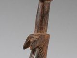 une image représentant une figurine en bois représentant une personne tenant un éventail