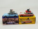 three toy cars are sitting on top of boxes on a white surface