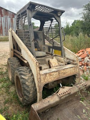 a small tractor that is parked in the dirt