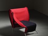 a red chair with a black seat in a dark room
