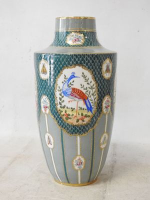 a blue vase with a bird on it sitting on a table