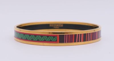 un gros plan d'un bracelet rouge et vert posé sur une surface blanche