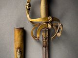 an old sword with a gold handle and a wooden handle
