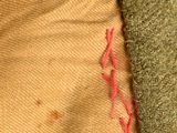 a close up of a piece of cloth with red stitches on it