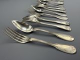 une multitude de fourchettes et de cuillères alignées sur une table