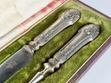 deux couverts dans un coffret recouvert d'un tissu vert