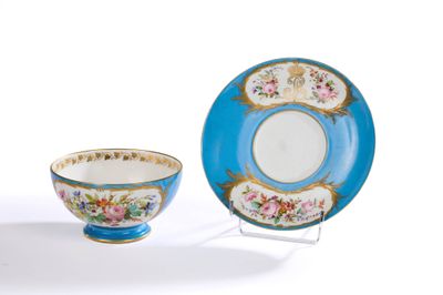 une tasse et une soucoupe posées sur un support à côté d'une assiette