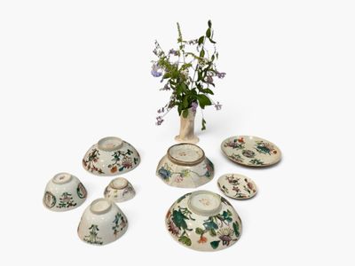 a vase with flowers in it sitting next to a set of dishes