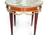 a small table with a marble top and red legs