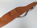 a brown leather guitar case on a white table