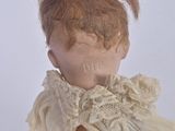 a close up of a doll ' s head with a lace collar