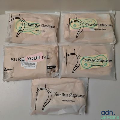 four bags of soap sitting on top of a white counter