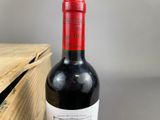 a bottle of wine sitting on a table next to a wooden box