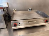 un plan de travail en acier inoxydable équipé d'une plaque de cuisson électrique et d'un grille-pain