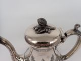 a silver tea pot with a bird on it
