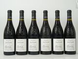 six bouteilles de vin sont alignées sur une table