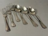 five spoons and a fork on a table