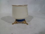 un vase blanc et bleu sur un support sur une surface blanche