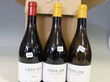 three bottles of wine are in a cardboard box on a table