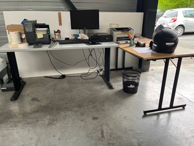 a computer desk with a helmet on it in a garage