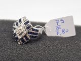 bague en argent ornée de pierres bleues et sur laquelle est accrochée une étiquette de prix
