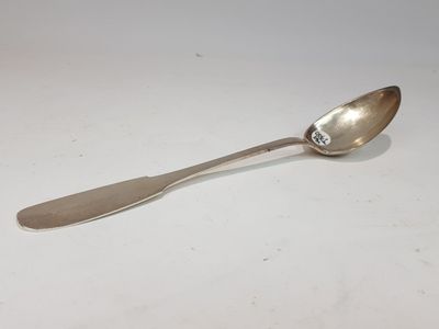silver spoon on a white surface with a small silver spoon on it