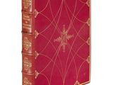 un vieux livre rouge aux tranches dorées, avec une croix sur la couverture