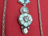 silver and turquoise necklace and bracelet set on a red cloth