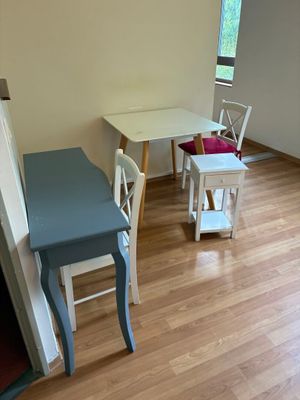 une petite table et des chaises dans une pièce au sol en parquet