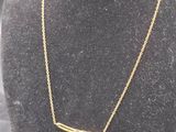 un collier en or sur un mannequin, sur fond noir