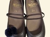 a close up of a pair of shoes with a pom - pom on them