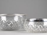 paire de verres en cristal taillé, bordés d'argent, sur un fond blanc