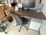 un bureau sur lequel se trouve un ordinateur, avec une chaise devant