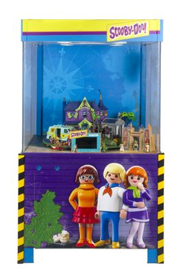 un gros plan sur une figurine Playmobil représentant trois personnes devant un bâtiment