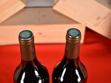 two bottles of wine sitting next to each other on a table