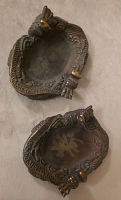 une paire de cendriers anciens en laiton sur fond blanc