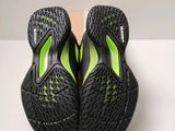a pair of black and green shoes on a white surface